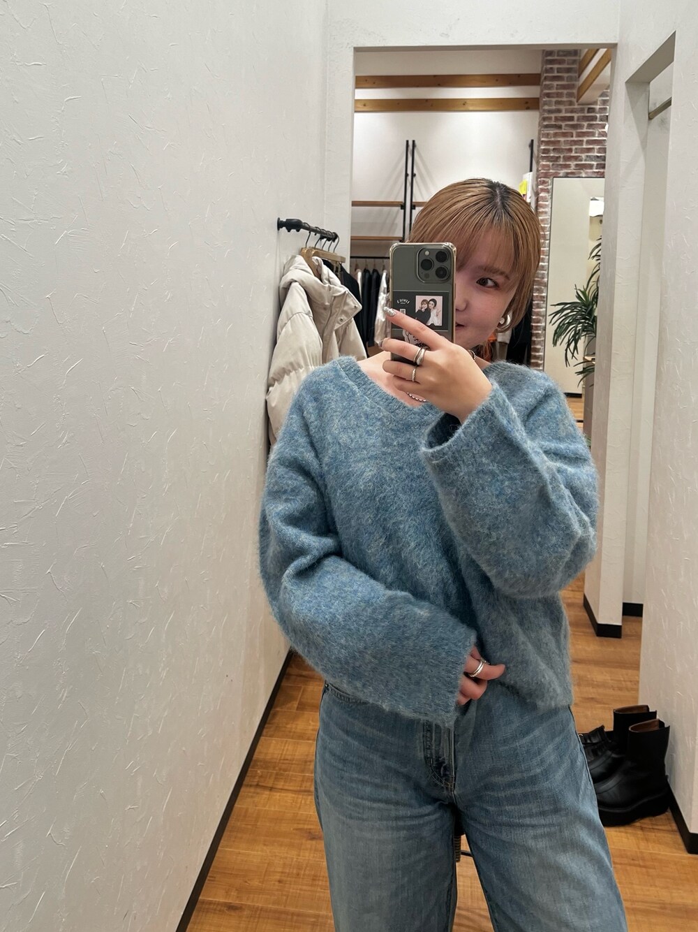 グリーン系のニット/セーター、ブルー系のデニムパンツを着用したレディースの冬コーディネートの1枚目の写真