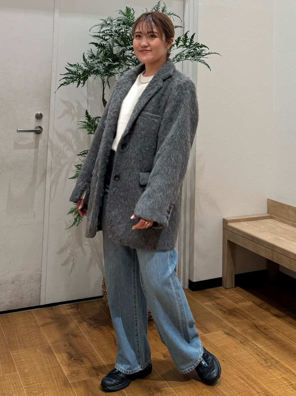 グレー系のテーラードジャケット、ブルー系のデニムパンツ、ホワイト系のニット/セーターを着用したレディースの秋コーディネートの1枚目の写真