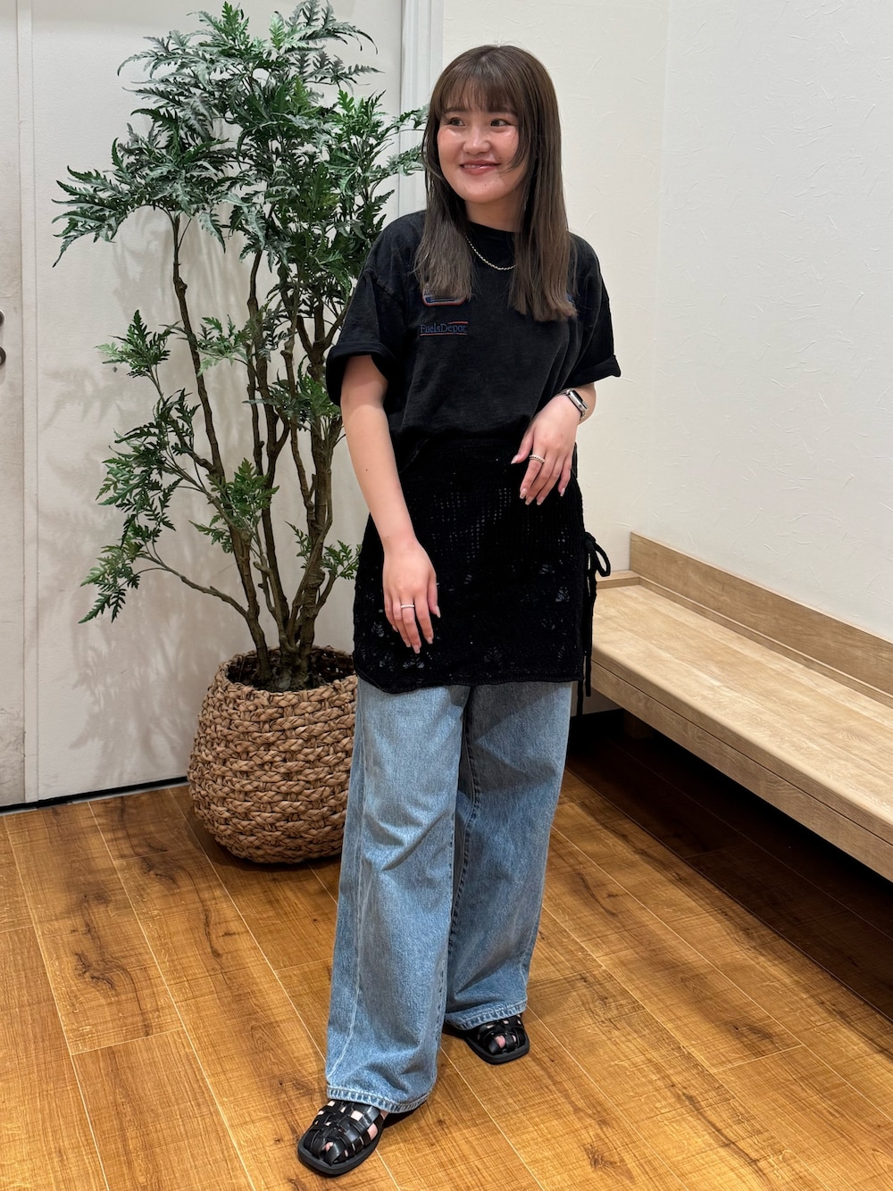ブラック系のTシャツ/カットソー、ブラック系のスカート、ブルー系のデニムパンツを着用したレディースの春コーディネートの1枚目の写真