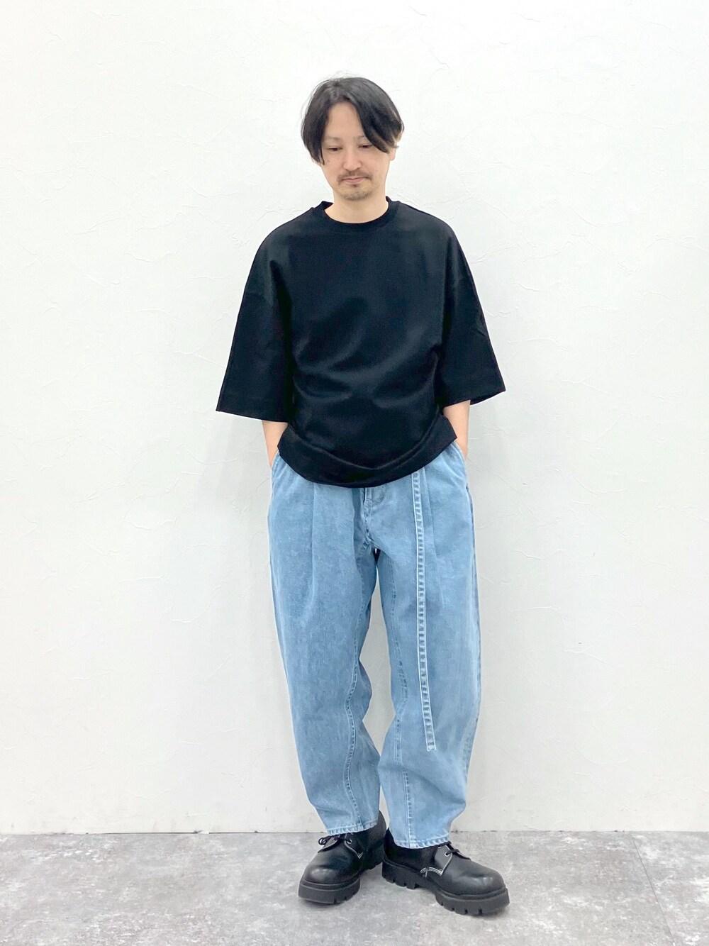 ブラック系のTシャツ/カットソー、ブルー系のデニムパンツを着用したメンズの春コーディネートの1枚目の写真