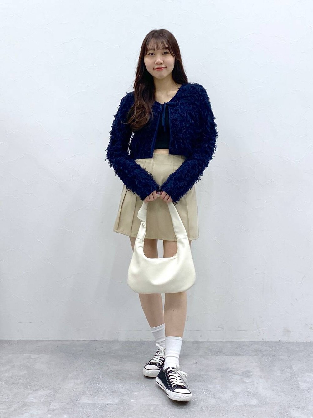 ベージュ系のスカート、ブルー系のカーディガン/ボレロを着用したレディースの春コーディネートの1枚目の写真