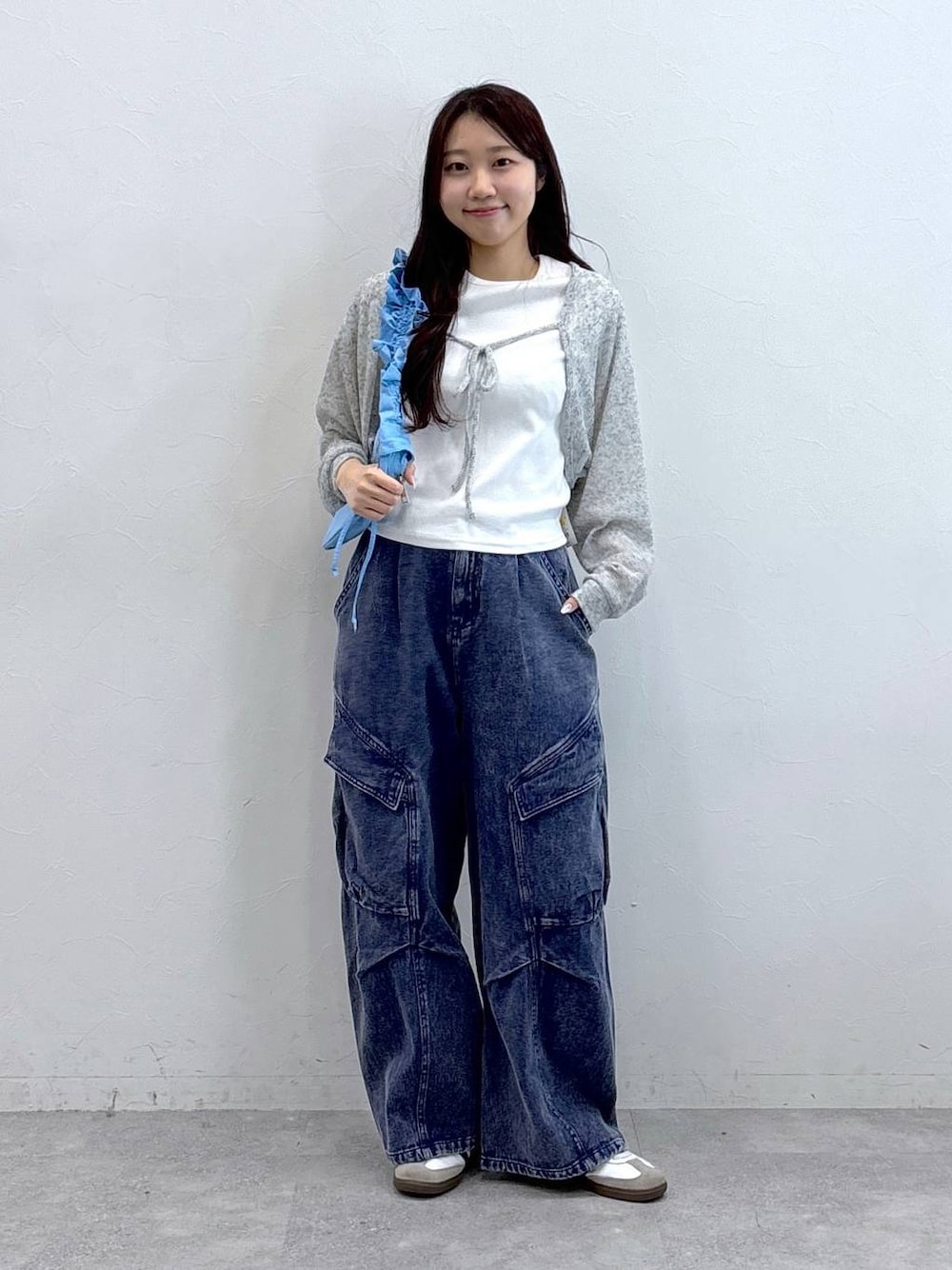 ブルー系のショルダーバッグ、パープル系のカーゴパンツ、ベージュ系のTシャツ/カットソーを着用したレディースの春コーディネートの1枚目の写真