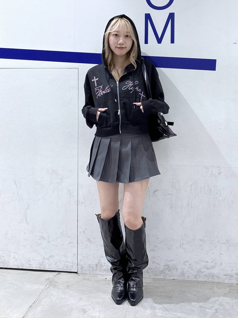 ブラック系のパーカー、ブラック系のブーツ、ブラック系のショルダーバッグを着用したレディースの冬コーディネートの1枚目の写真