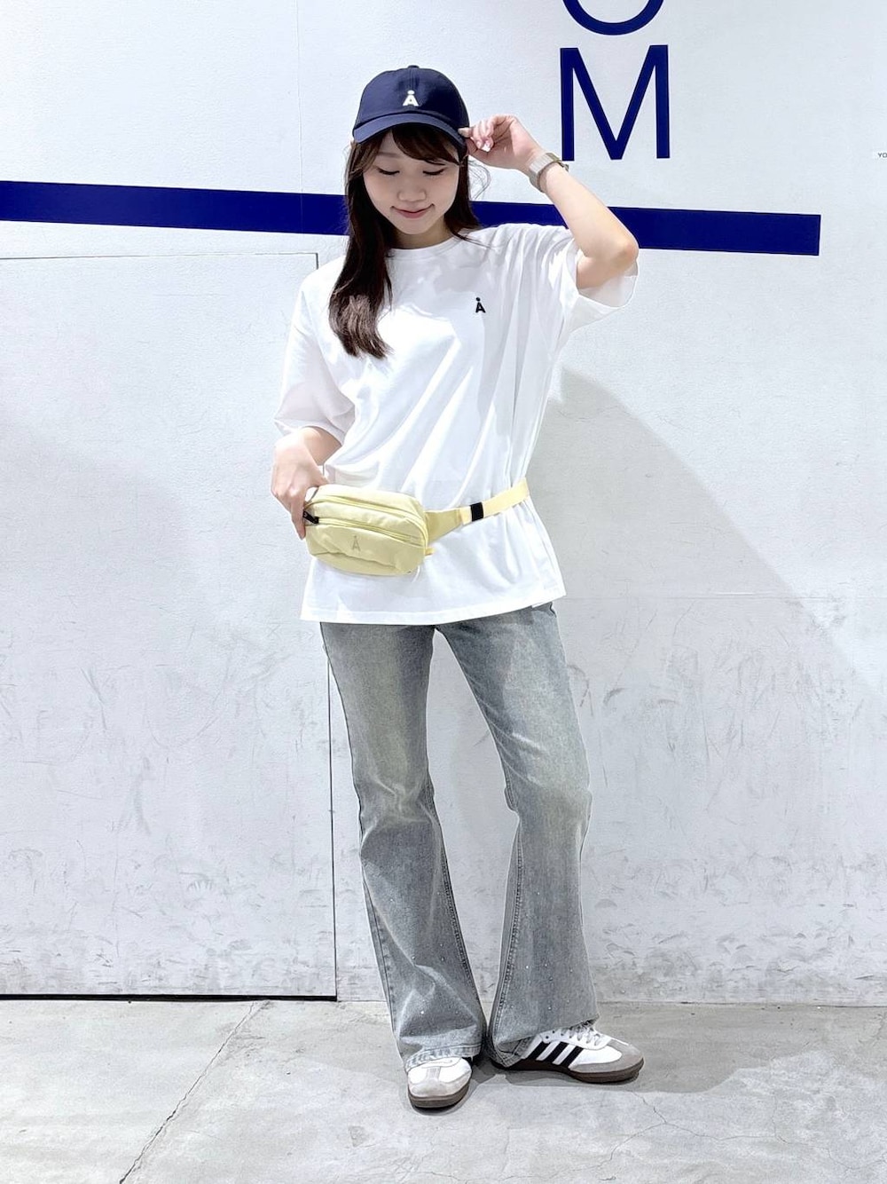 ベージュ系のボディバッグ/ウエストポーチ、ホワイト系のTシャツ/カットソー、ブルー系のデニムパンツを着用したレディースの夏コーディネートの1枚目の写真