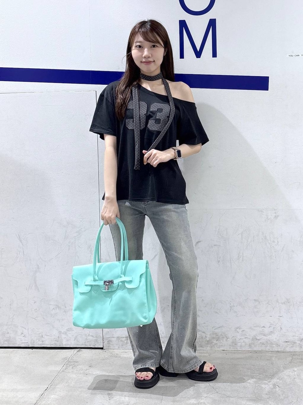 グリーン系のショルダーバッグ、ブラック系のサンダル、ブラック系のTシャツ/カットソーを着用したレディースの夏コーディネートの1枚目の写真