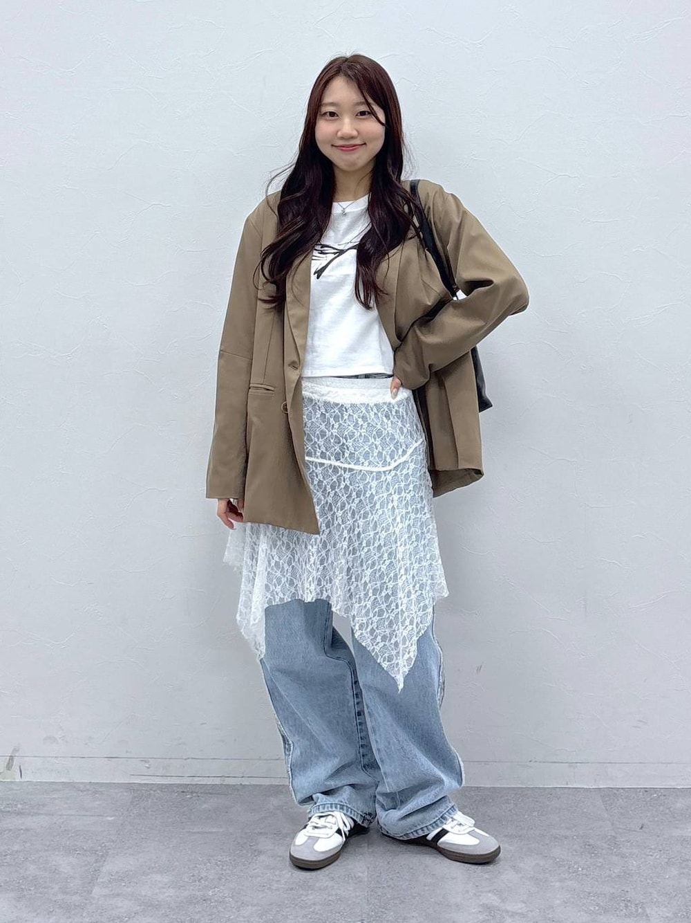 ブラウン系のテーラードジャケット、ホワイト系のスカート、ホワイト系のTシャツ/カットソーを着用したレディースの春コーディネートの1枚目の写真