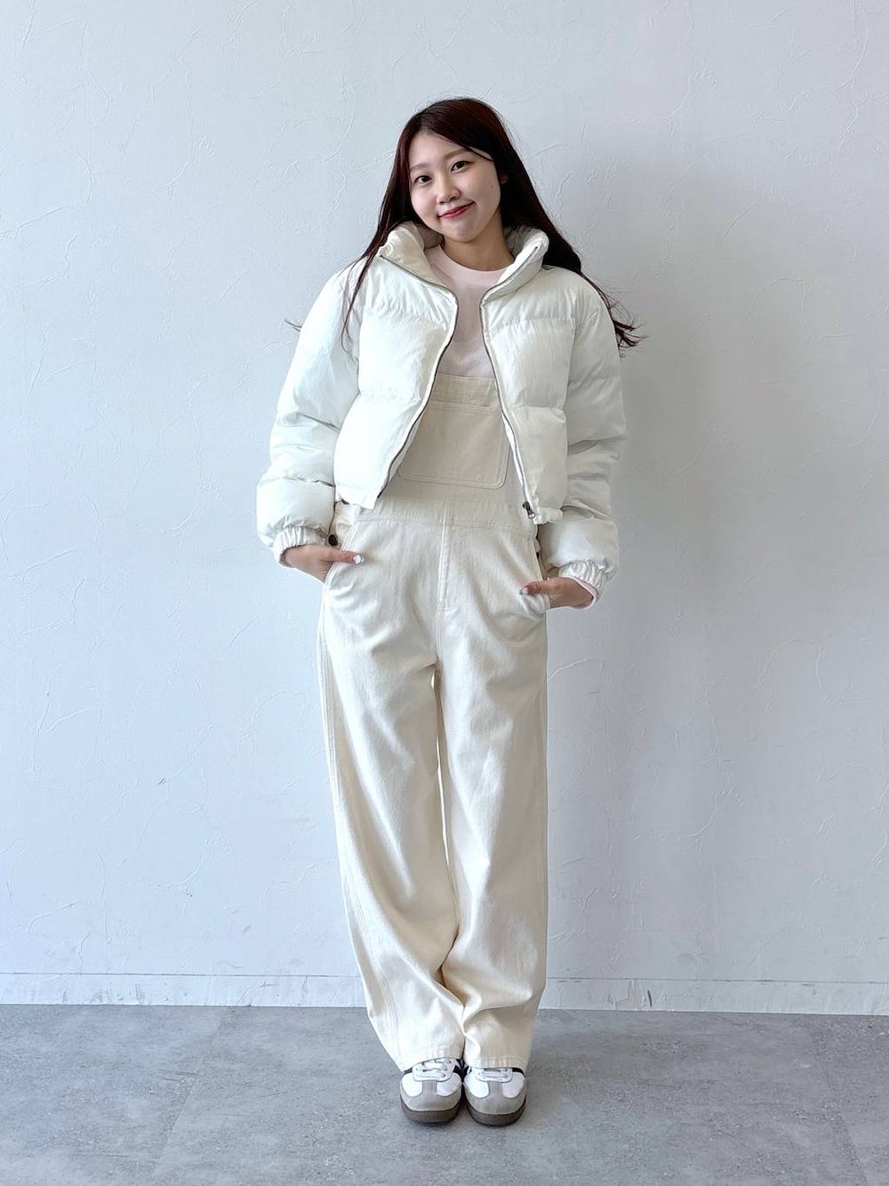 ベージュ系のダウンジャケット/コート、ホワイト系のデニムパンツ、ピンク系のTシャツ/カットソーを着用したレディースの秋コーディネートの1枚目の写真