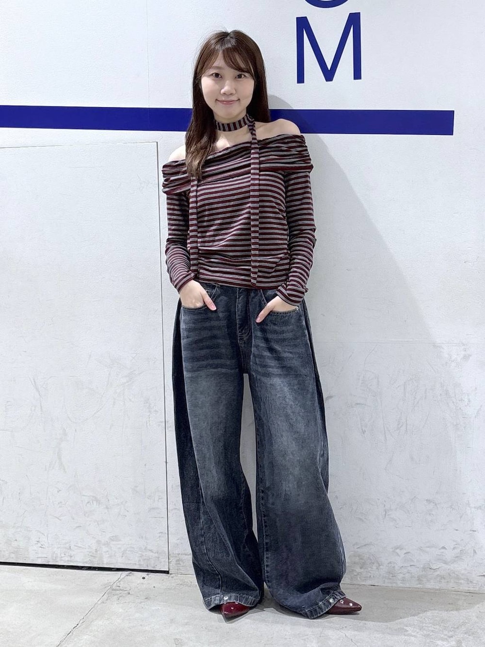 レッド系のTシャツ/カットソー、ブルー系のデニムパンツ、レッド系のサンダルを着用したレディースの秋コーディネートの1枚目の写真