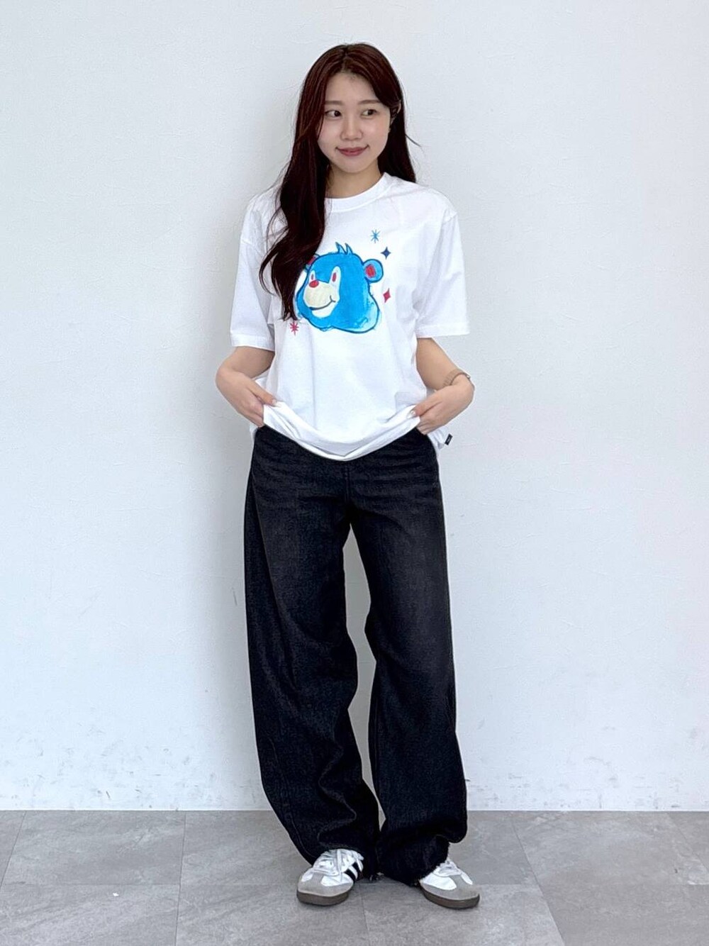 ブラック系のデニムパンツ、ホワイト系のTシャツ/カットソーを着用したレディースの春コーディネートの1枚目の写真