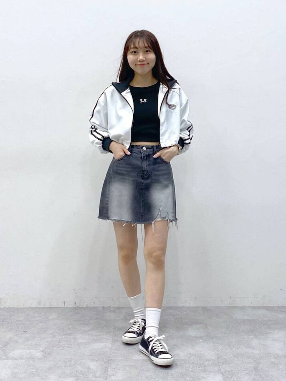 ホワイト系のブルゾン、ブラック系のデニムスカート、ブラック系のTシャツ/カットソーを着用したレディースの春コーディネートの1枚目の写真