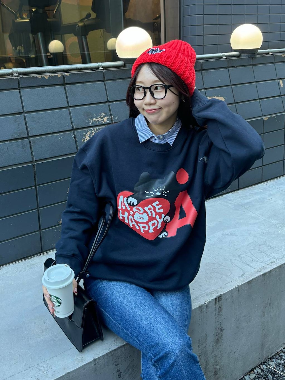 ブルー系のデニムパンツ、ブラック系のショルダーバッグ、ブルー系のスウェットを着用したレディースの冬コーディネートの1枚目の写真