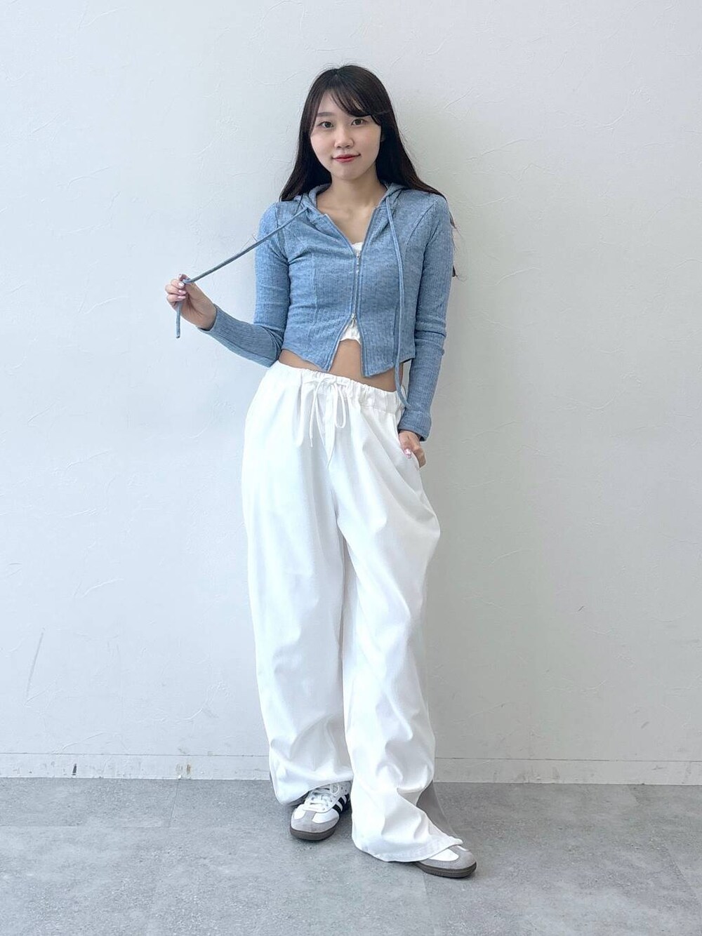 ベージュ系のカーゴパンツ、ベージュ系のチューブトップ、ブルー系のTシャツ/カットソーを着用したレディースの春コーディネートの1枚目の写真