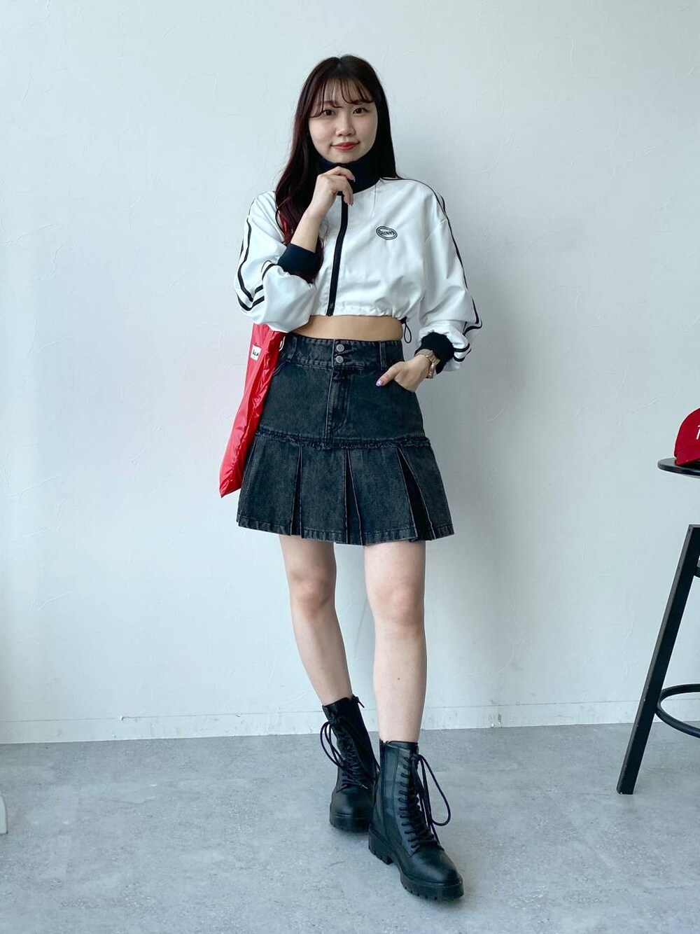 ホワイト系のブルゾン、レッド系のトートバッグ、ブラック系のデニムスカートを着用したレディースの春コーディネートの1枚目の写真