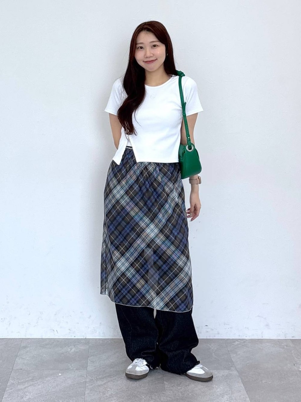 ブラック系のデニムパンツ、ブルー系のスカートを着用したレディースの春コーディネートの1枚目の写真