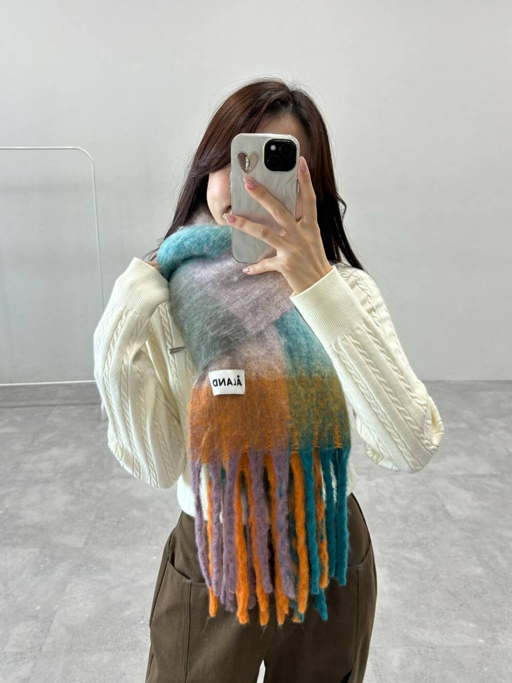 ホワイト系のTシャツ/カットソー、ブラウン系のその他パンツ、オレンジ系のマフラーを着用したレディースの秋コーディネートの1枚目の写真
