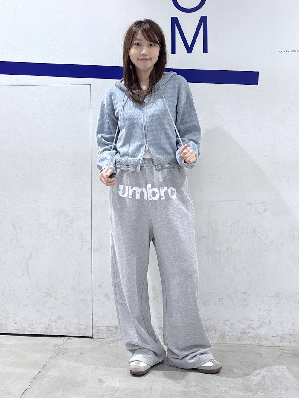 グレー系のスウェットパンツ、ブルー系のニット/セーターを着用したレディースの秋コーディネートの1枚目の写真