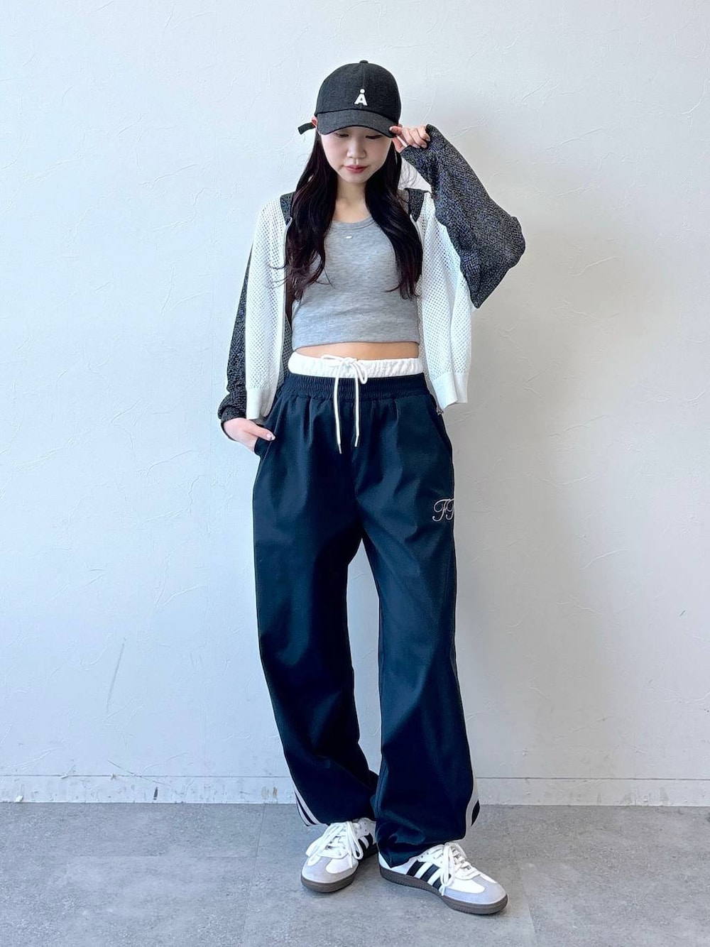 ブルー系のその他パンツ、グレー系のタンクトップ、ブラック系のキャップを着用したレディースの冬コーディネートの1枚目の写真