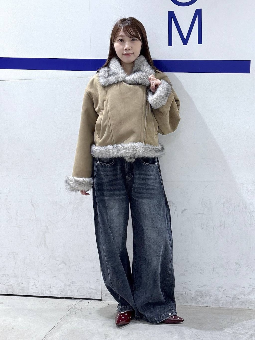 レッド系のTシャツ/カットソー、ブルー系のデニムパンツ、グレー系のムートンコートを着用したレディースの秋コーディネートの1枚目の写真