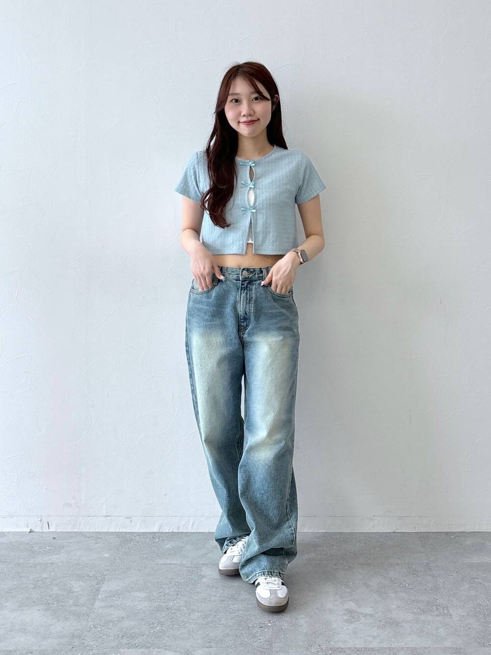 ブルー系のデニムパンツ、ベージュ系のチューブトップ、ブルー系のTシャツ/カットソーを着用したレディースの春コーディネートの1枚目の写真