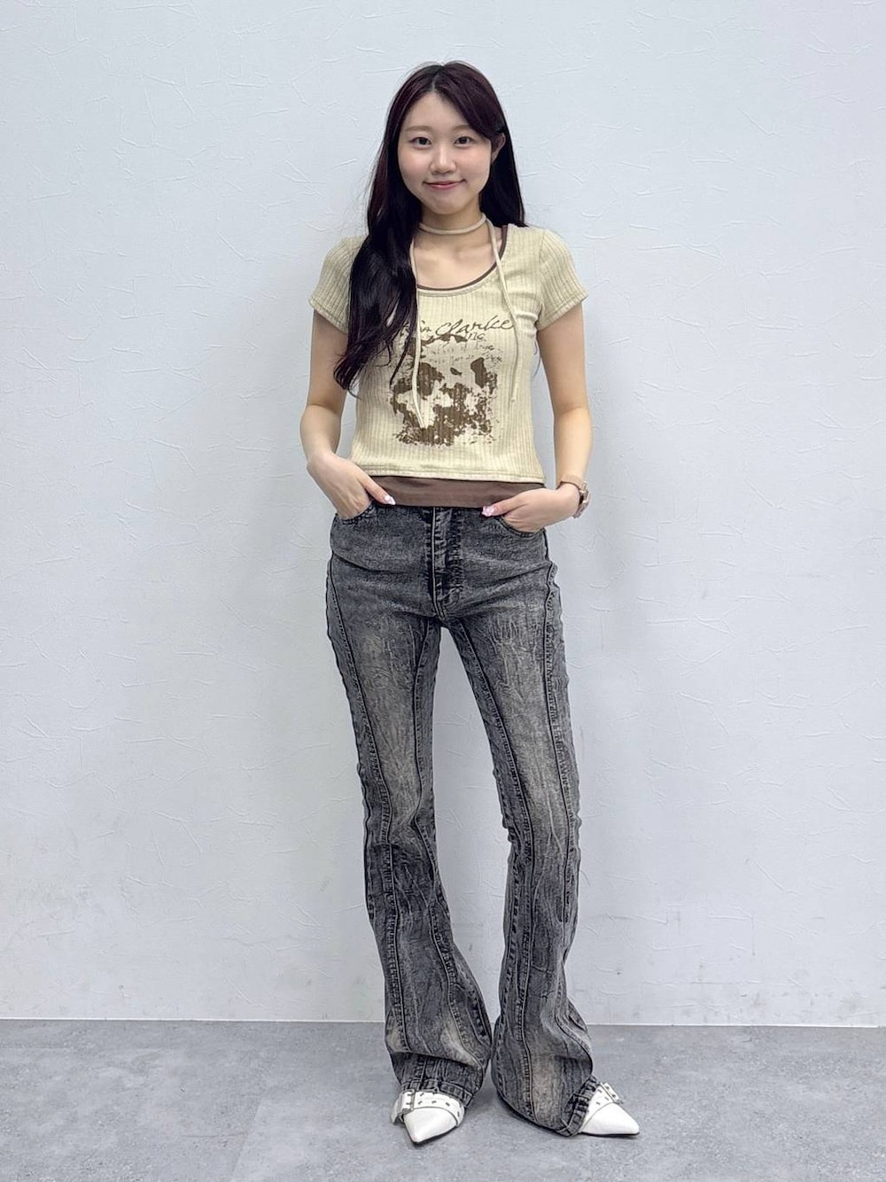 ベージュ系のサンダル、ベージュ系のTシャツ/カットソー、ブラック系のデニムパンツを着用したレディースの春コーディネートの1枚目の写真