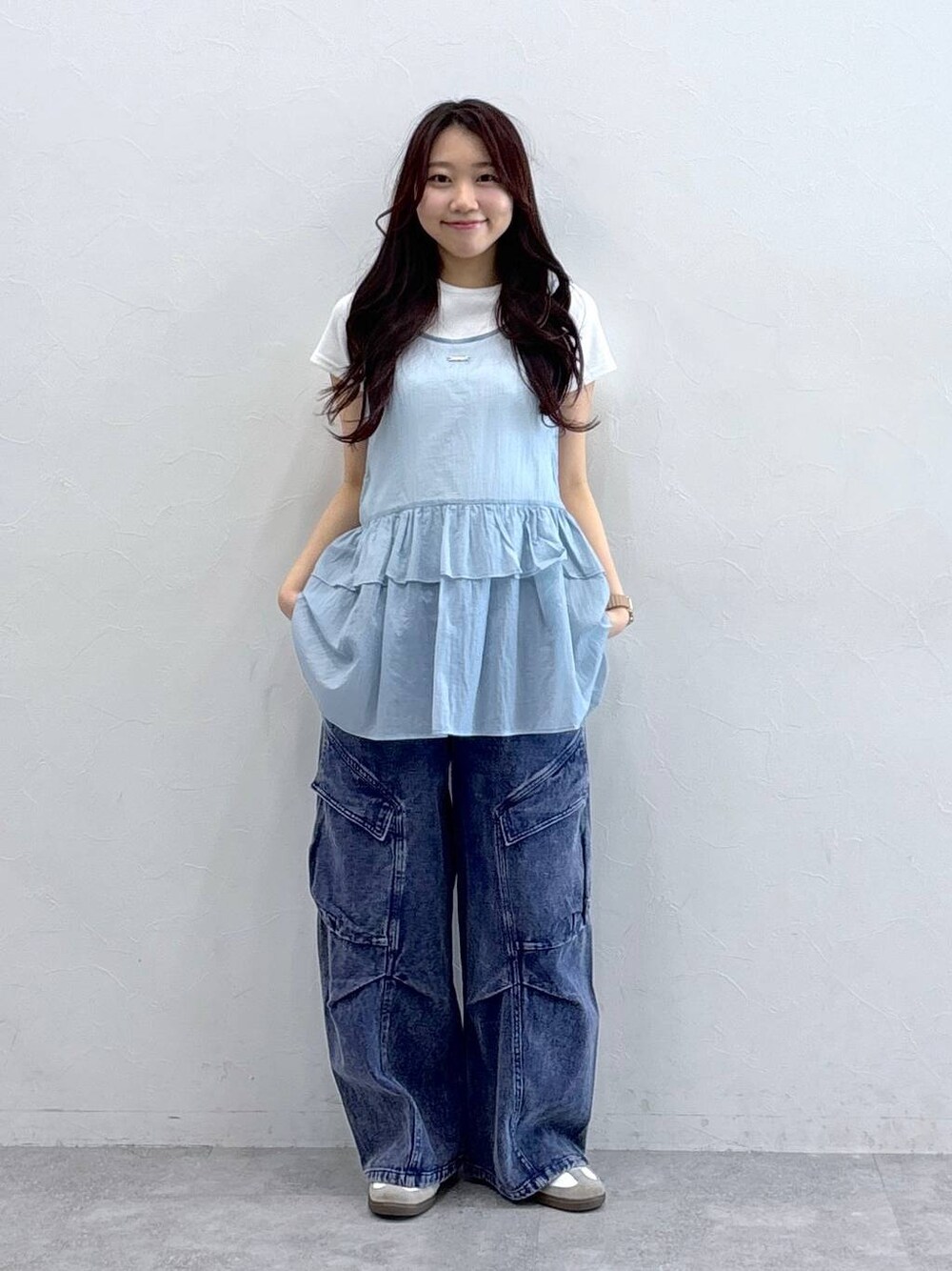 パープル系のカーゴパンツ、ブルー系のワンピース、ベージュ系のTシャツ/カットソーを着用したレディースの春コーディネートの1枚目の写真