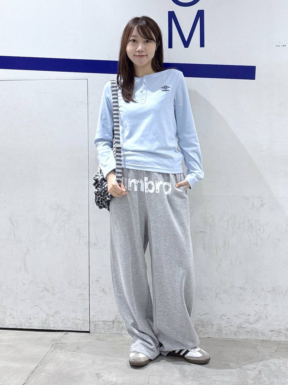 グレー系のスウェットパンツ、ブルー系のTシャツ/カットソー、グレー系のバックパック/リュックを着用したレディースの秋コーディネートの1枚目の写真