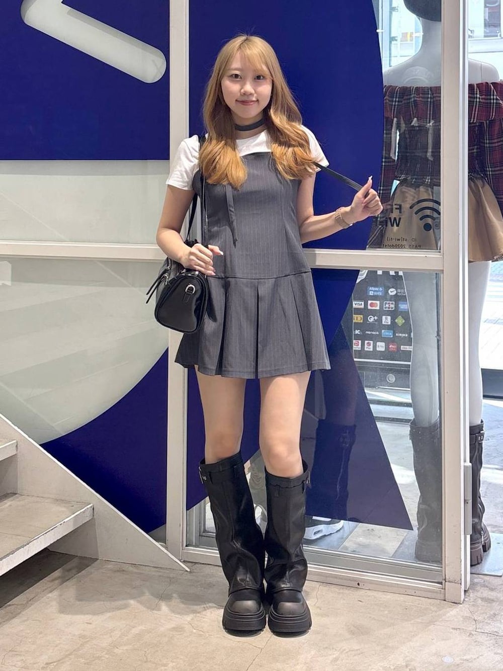 ホワイト系のTシャツ/カットソー、ブラック系のハンドバッグ、ブラック系のブーツを着用したレディースの夏コーディネートの1枚目の写真