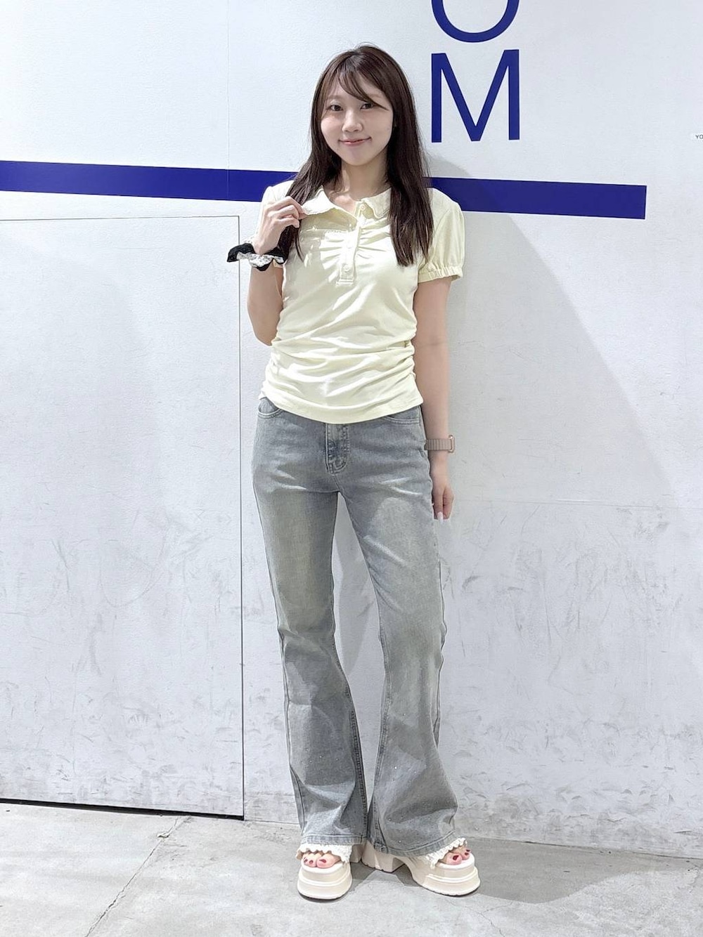 ホワイト系のサンダル、ベージュ系のTシャツ/カットソー、ブルー系のデニムパンツを着用したレディースの夏コーディネートの1枚目の写真