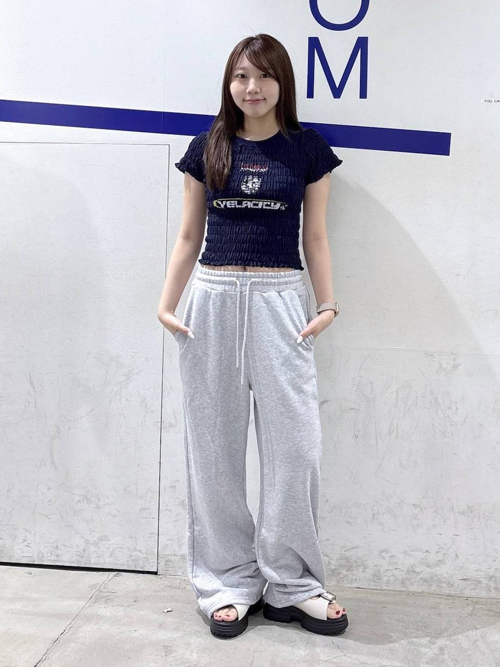 ホワイト系のサンダル、ブルー系のTシャツ/カットソー、グレー系のスウェットパンツを着用したレディースの夏コーディネートの1枚目の写真