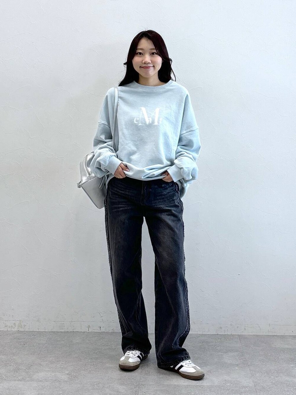 グレー系のバックパック/リュック、ブラック系のデニムパンツ、ブルー系のスウェットを着用したレディースの冬コーディネートの1枚目の写真