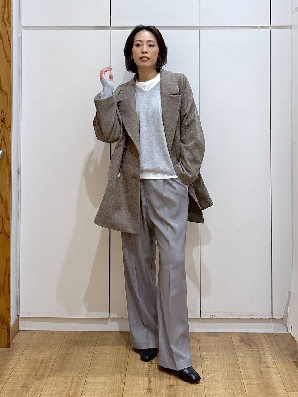 ブラウン系のチェスターコート、グレー系のその他パンツ、ホワイト系のTシャツ/カットソーを着用したレディースの秋コーディネートの1枚目の写真