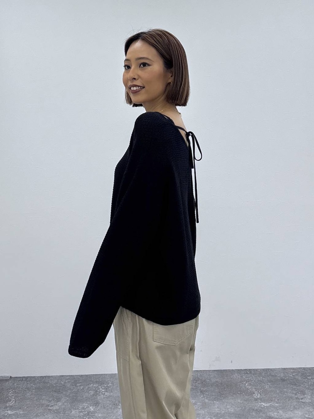 ベージュ系のその他パンツ、ゴールド系のネックレスを着用したレディースの春コーディネートの1枚目の写真