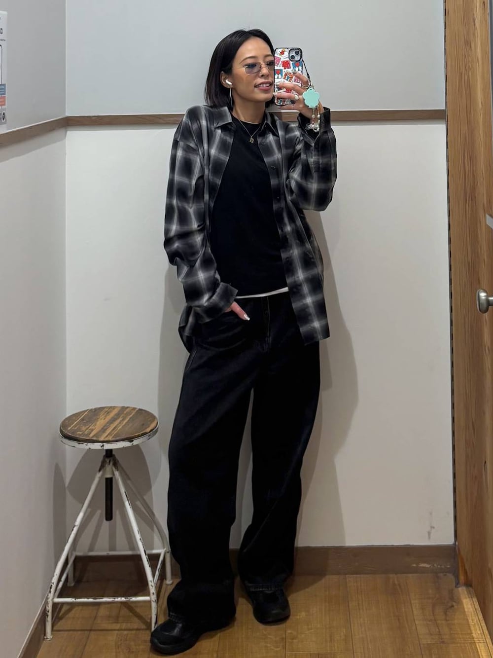 ブラック系のシャツ/ブラウス、ブルー系のデニムパンツ、ブラック系のスニーカーを着用したレディースの秋コーディネートの1枚目の写真