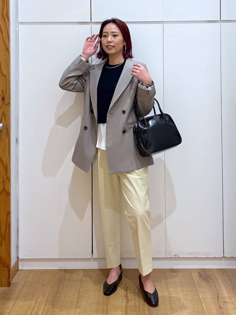 イエロー系のその他パンツ、ブラック系のボストンバッグ、ブラック系のニット/セーターを着用したレディースの春コーディネートの1枚目の写真