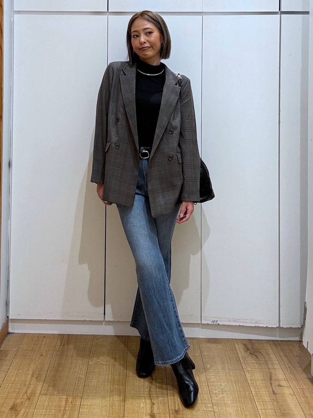 ブラック系のトートバッグ、ブラック系のTシャツ/カットソー、ブラック系のブーツを着用したレディースの秋コーディネートの1枚目の写真