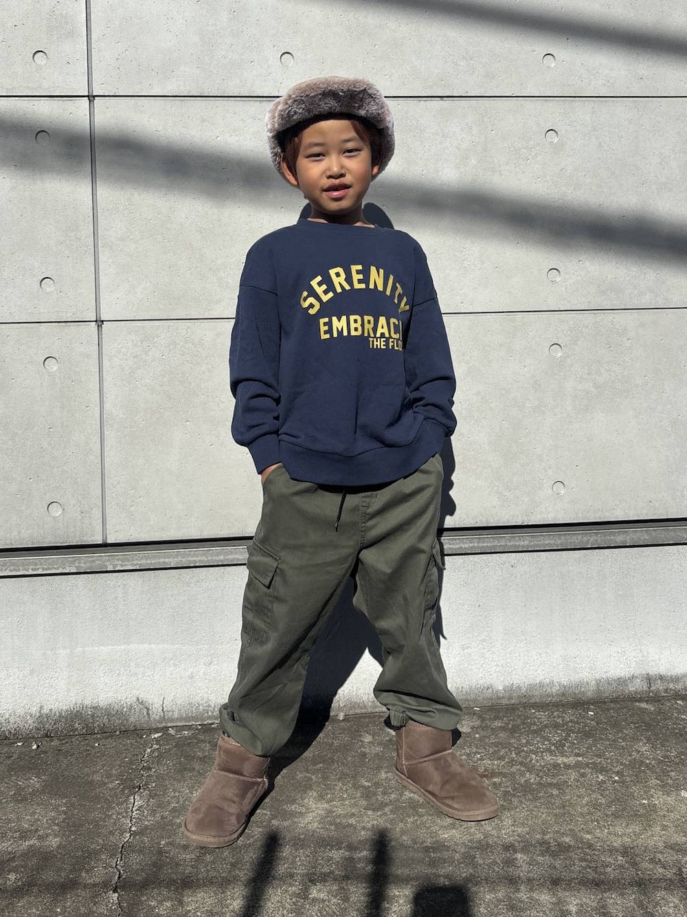 ブルー系のスウェット、グリーン系のカーゴパンツ、ブラウン系のブーツを着用したキッズの秋コーディネートの1枚目の写真