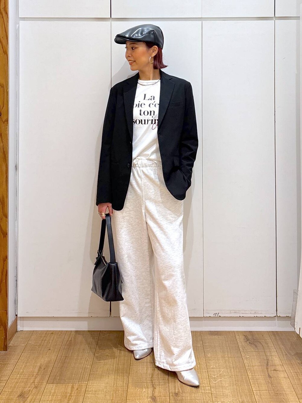 ブラック系のテーラードジャケット、ブラック系のショルダーバッグ、ホワイト系のTシャツ/カットソーを着用したレディースの春コーディネートの1枚目の写真
