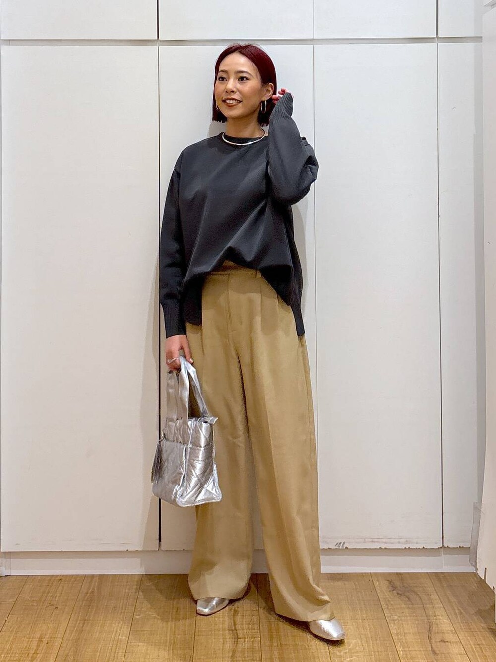 シルバー系のパンプス、グレー系のニット/セーター、シルバー系のトートバッグを着用したレディースの春コーディネートの1枚目の写真