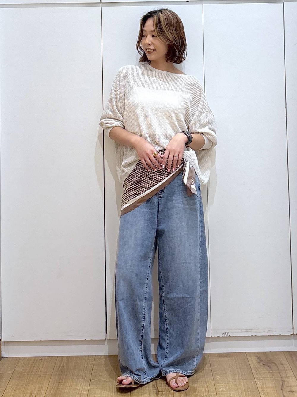ホワイト系のキャミソール、ブルー系のデニムパンツ、ホワイト系のニット/セーターを着用したレディースの春コーディネートの1枚目の写真