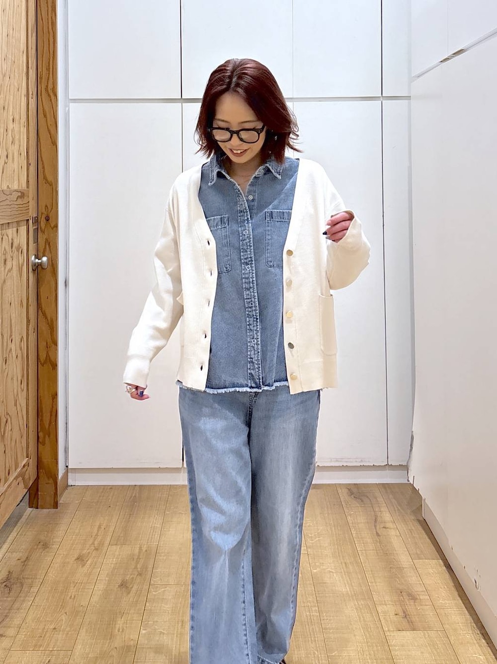 ブルー系のデニムパンツ、ベージュ系のカーディガン/ボレロ、ブルー系のシャツ/ブラウスを着用したレディースの春コーディネートの1枚目の写真