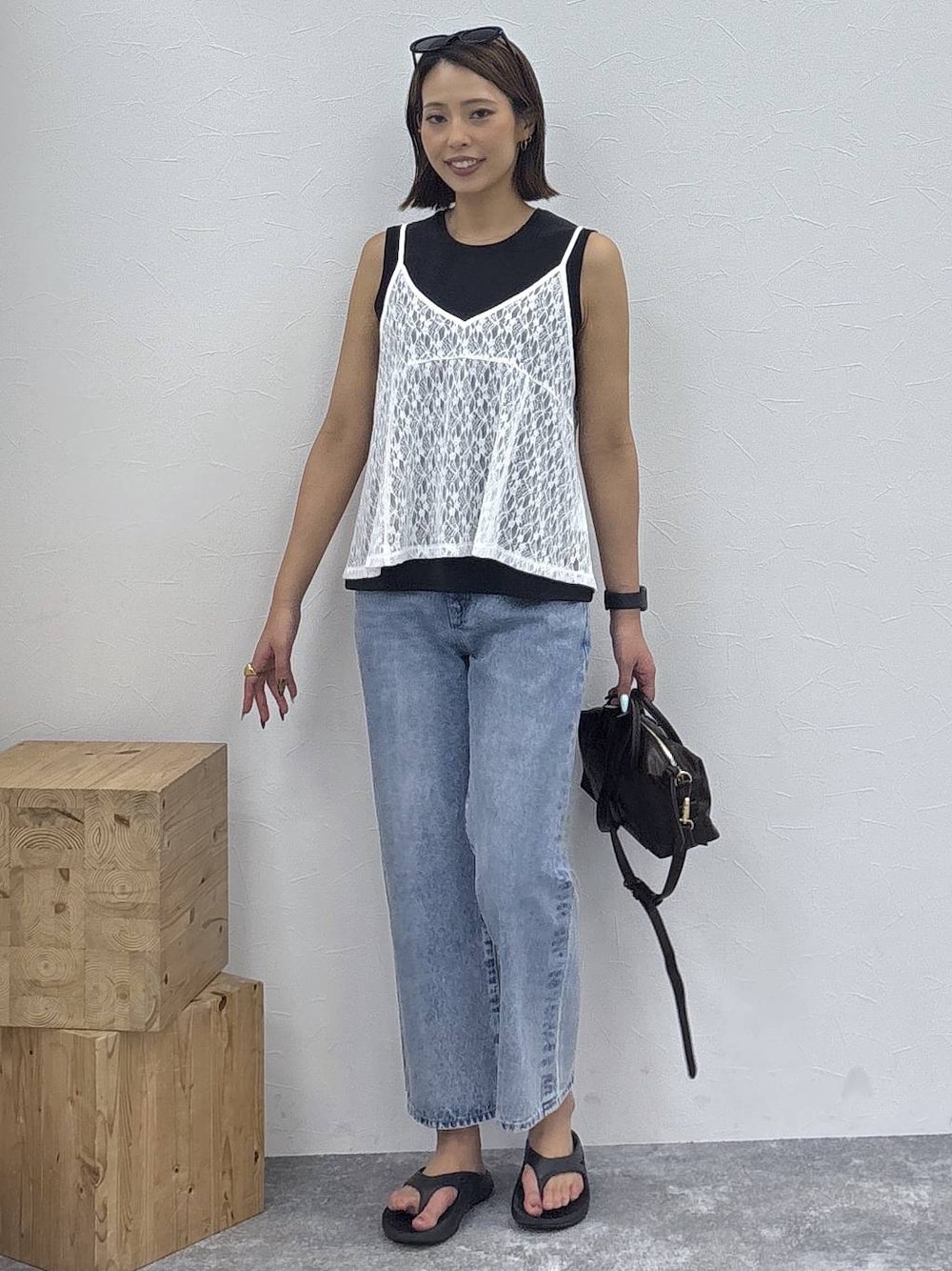 ブラック系のボストンバッグ、ブラック系のTシャツ/カットソー、ホワイト系のキャミソールを着用したレディースの夏コーディネートの1枚目の写真