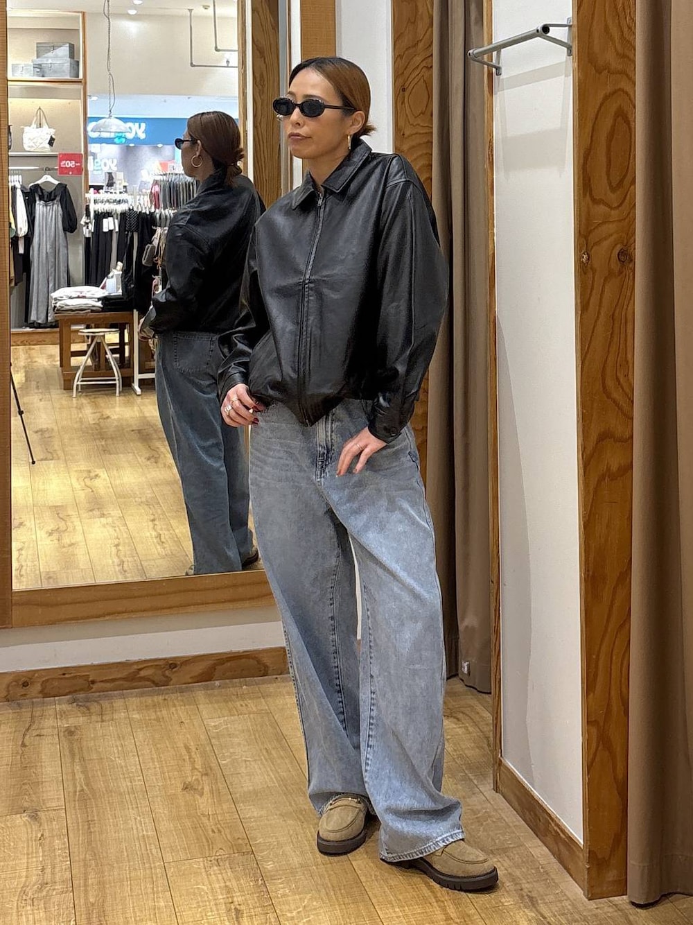 ブラック系のブルゾン、ブルー系のデニムパンツ、ベージュ系のローファーを着用したレディースの秋コーディネートの1枚目の写真