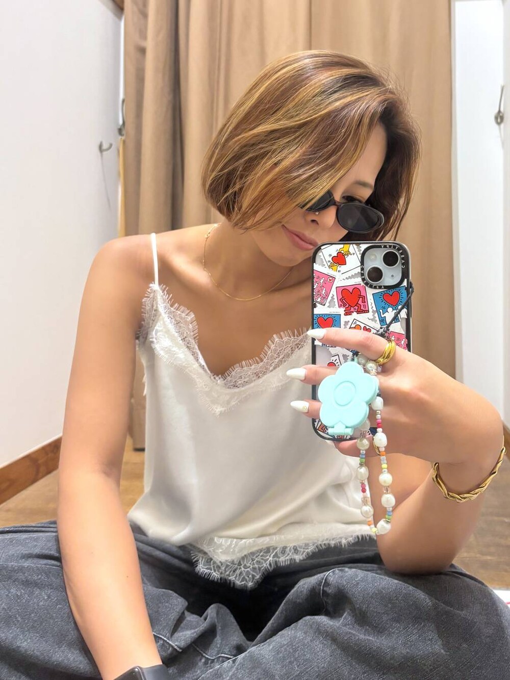 ブラック系のデニムパンツ、ホワイト系のキャミソールを着用したレディースの夏コーディネートの1枚目の写真