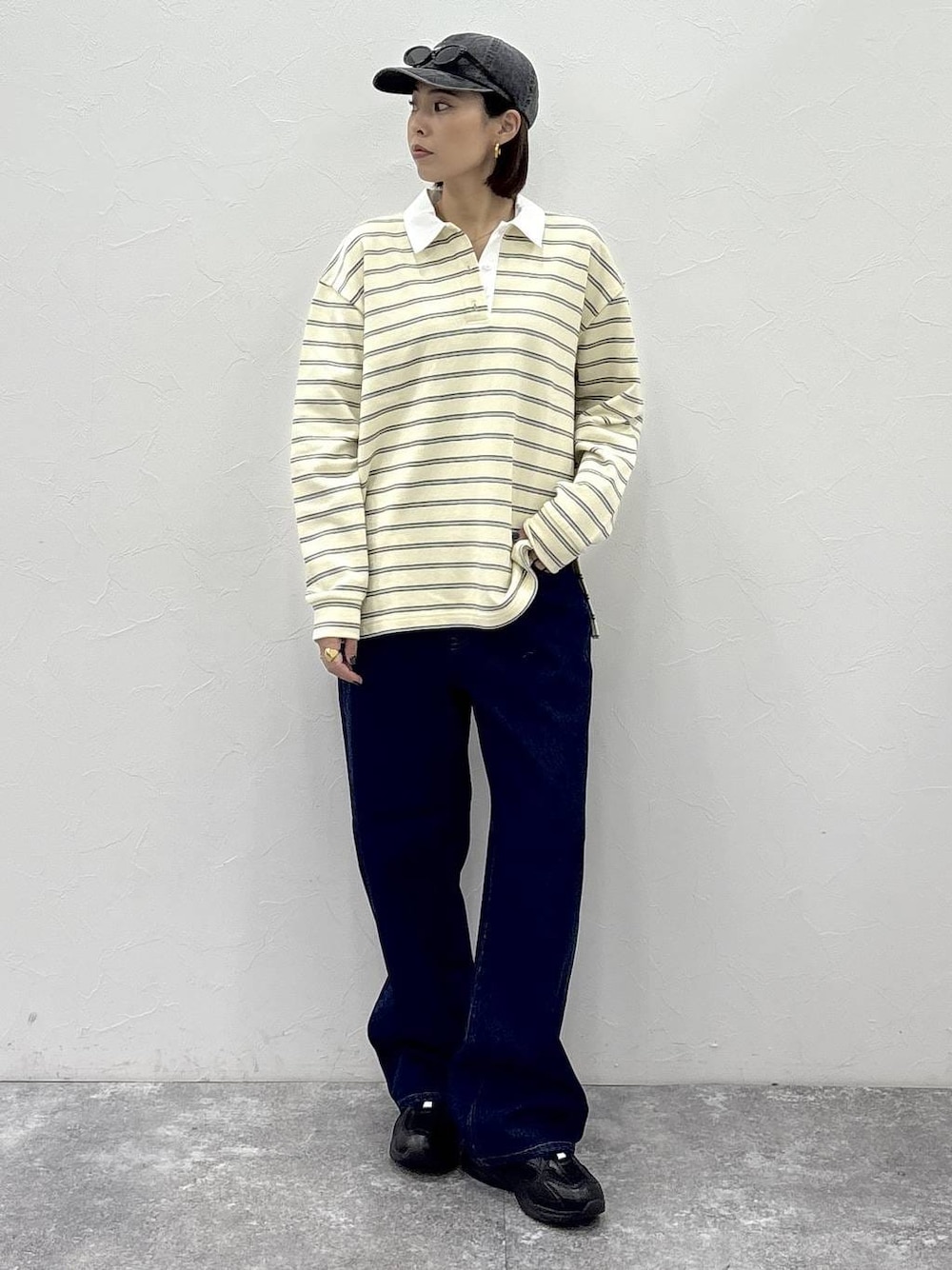 ブラック系のスニーカー、イエロー系のスウェット、ゴールド系のピアス(両耳用)を着用したレディースの冬コーディネートの1枚目の写真