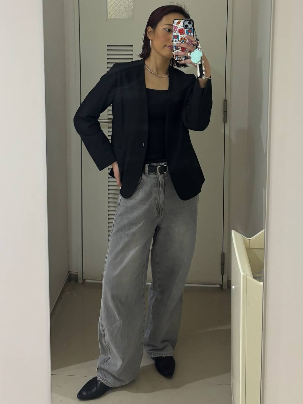 グレー系のデニムパンツ、ブラック系のノーカラージャケット、グレー系のチョーカーを着用したレディースの春コーディネートの1枚目の写真