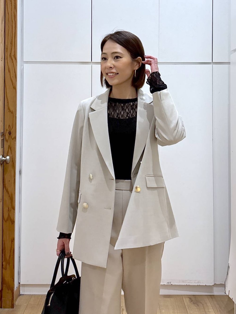 ブラック系のショルダーバッグ、ブラック系のパンプス、ブラック系のTシャツ/カットソーを着用したレディースの冬コーディネートの1枚目の写真