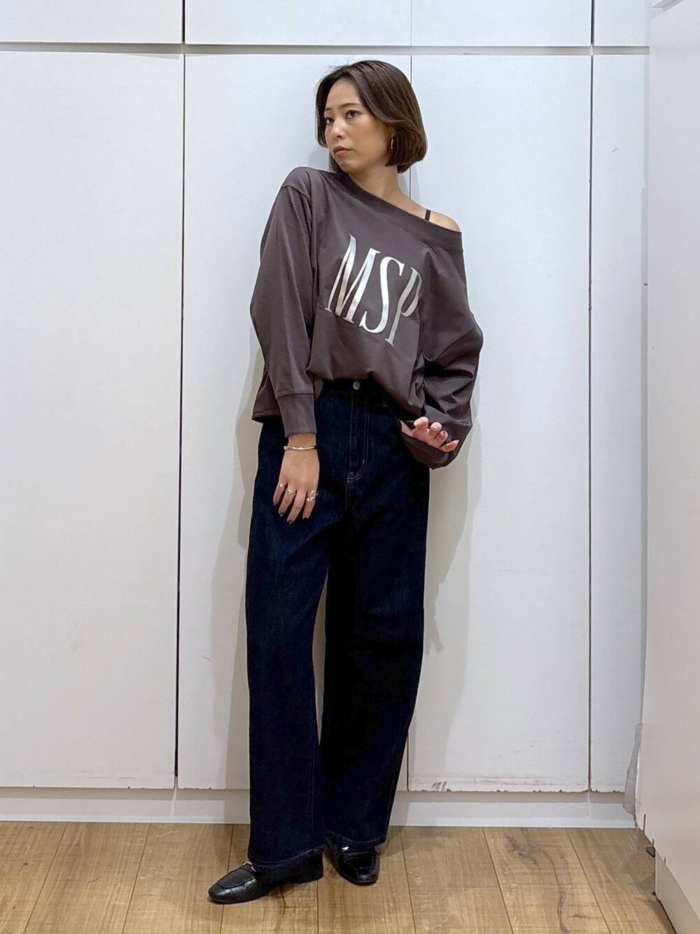 ブラック系のローファー、ブルー系のデニムパンツ、ブラウン系のスウェットを着用したレディースの秋コーディネートの1枚目の写真