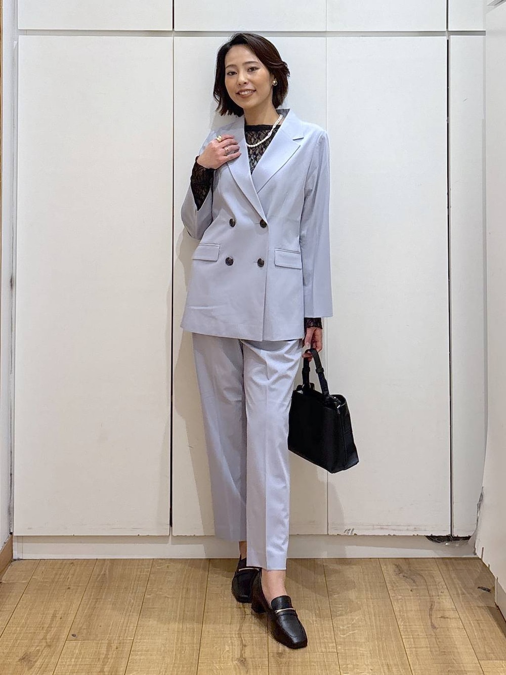 ブラック系のローファー、ブラック系のTシャツ/カットソー、ブルー系のスラックスを着用したレディースの冬コーディネートの1枚目の写真