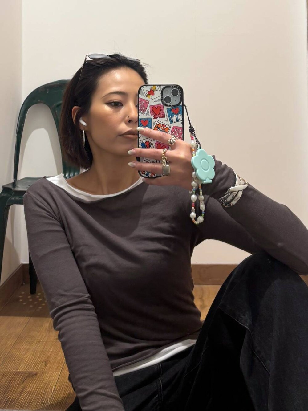 ブラック系のデニムパンツ、ブラック系のスニーカー、ホワイト系のTシャツ/カットソーを着用したレディースの秋コーディネートの1枚目の写真