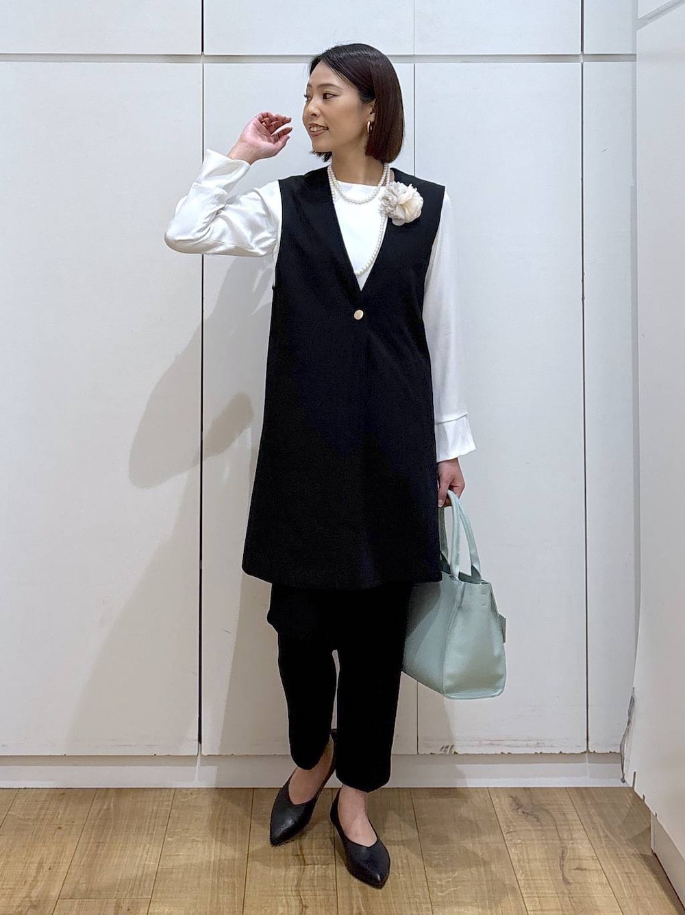 ブラック系のパンプス、ブラック系のスラックス、ブラック系のセットアップを着用したレディースの冬コーディネートの1枚目の写真